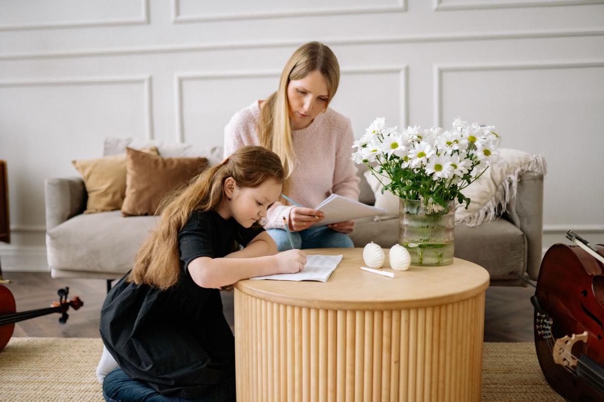 A mom and her daughter working through the week's plan together on the living-room floor.